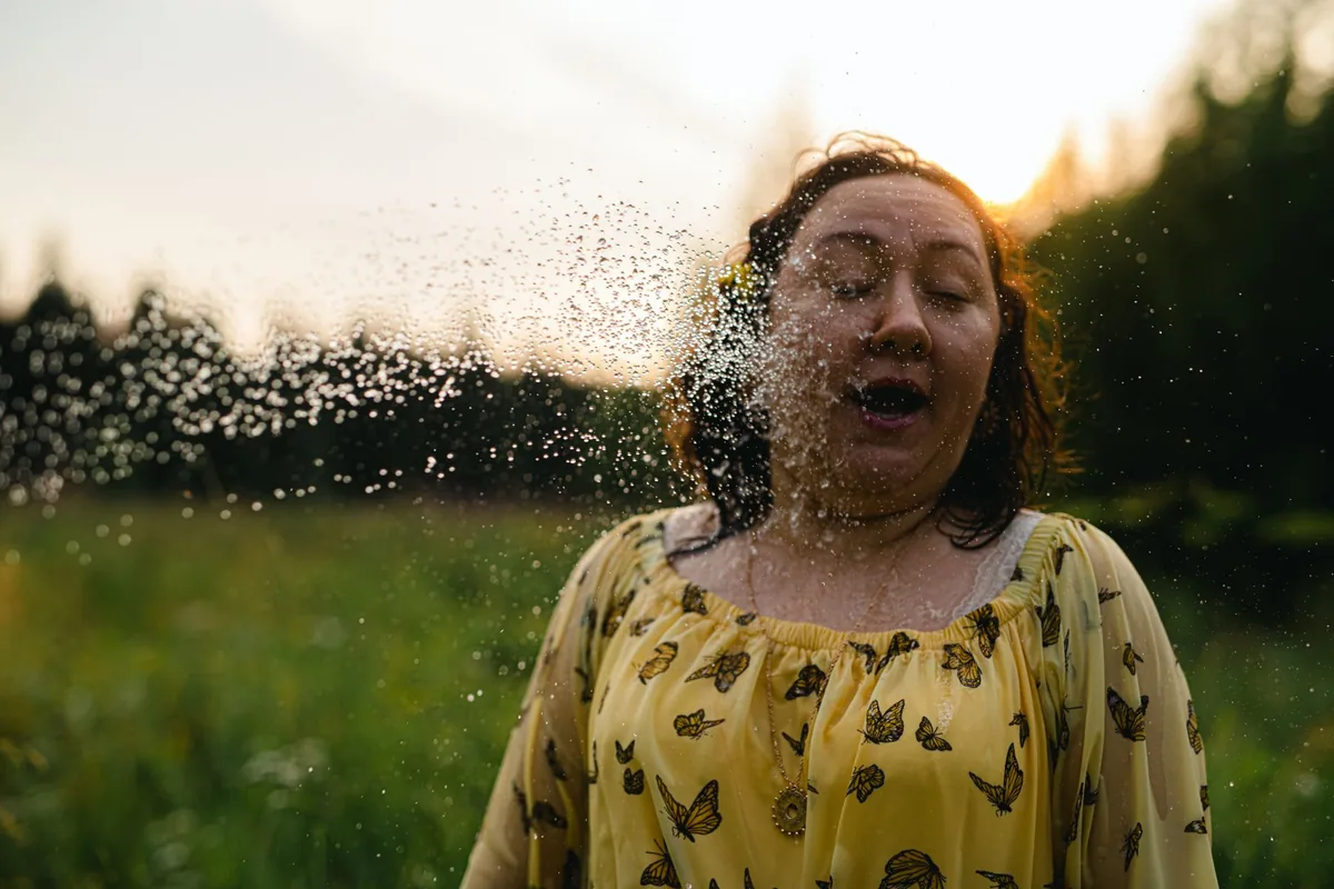 Žena na louce v oblaku poletujícího pylu