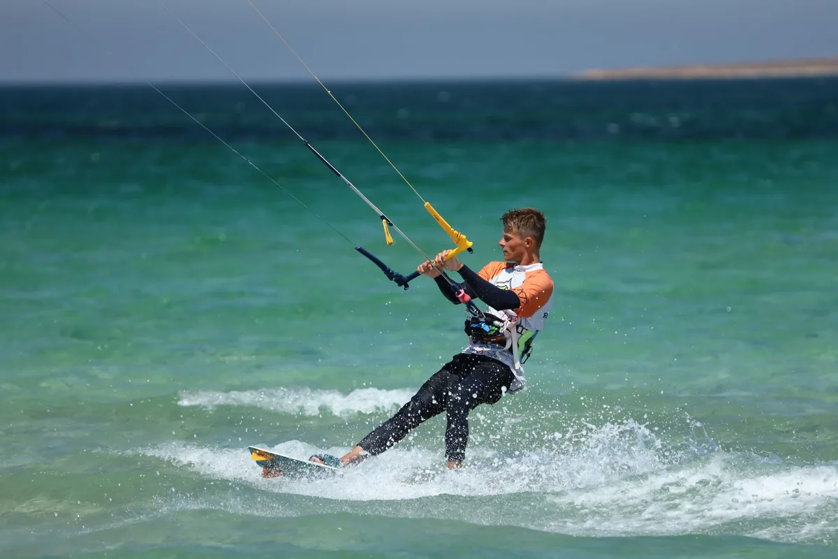 Kitesurfař jede po hladině tyrkysového moře
